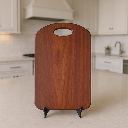 Handcrafted bloodwood charcuterie board with integrated handle on black display stand in a modern kitchen setting.