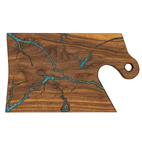Rectangular walnut charcuterie board with integrated handle, showcasing a cyan fractal burn pattern inlaid with food-safe epoxy.